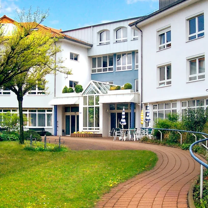 DRK Heinrich-Gerold-Haus - Am Schloßberg 5 in Ober-Ramstadt Moderne Gebäude mit Garten, Sitzgelegenheiten und Bäumen im Vordergrund.